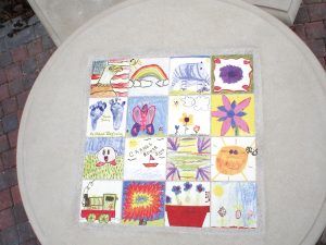 Children's artwork transferred onto tiles for an outdoor table